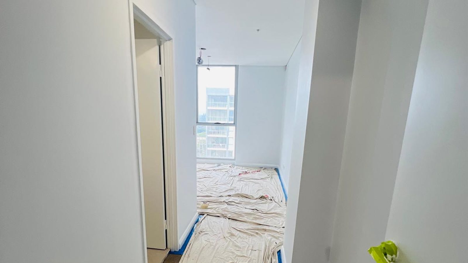 Apartment hall and room with the walls and ceiling set and the floor protected