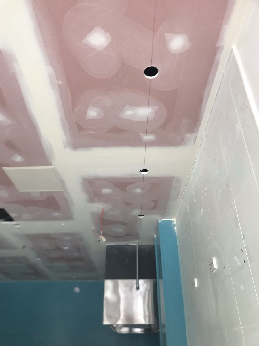 Bathroom ceiling sheeted and the joints coated above tiled walls, with the wall lining continuing down behind