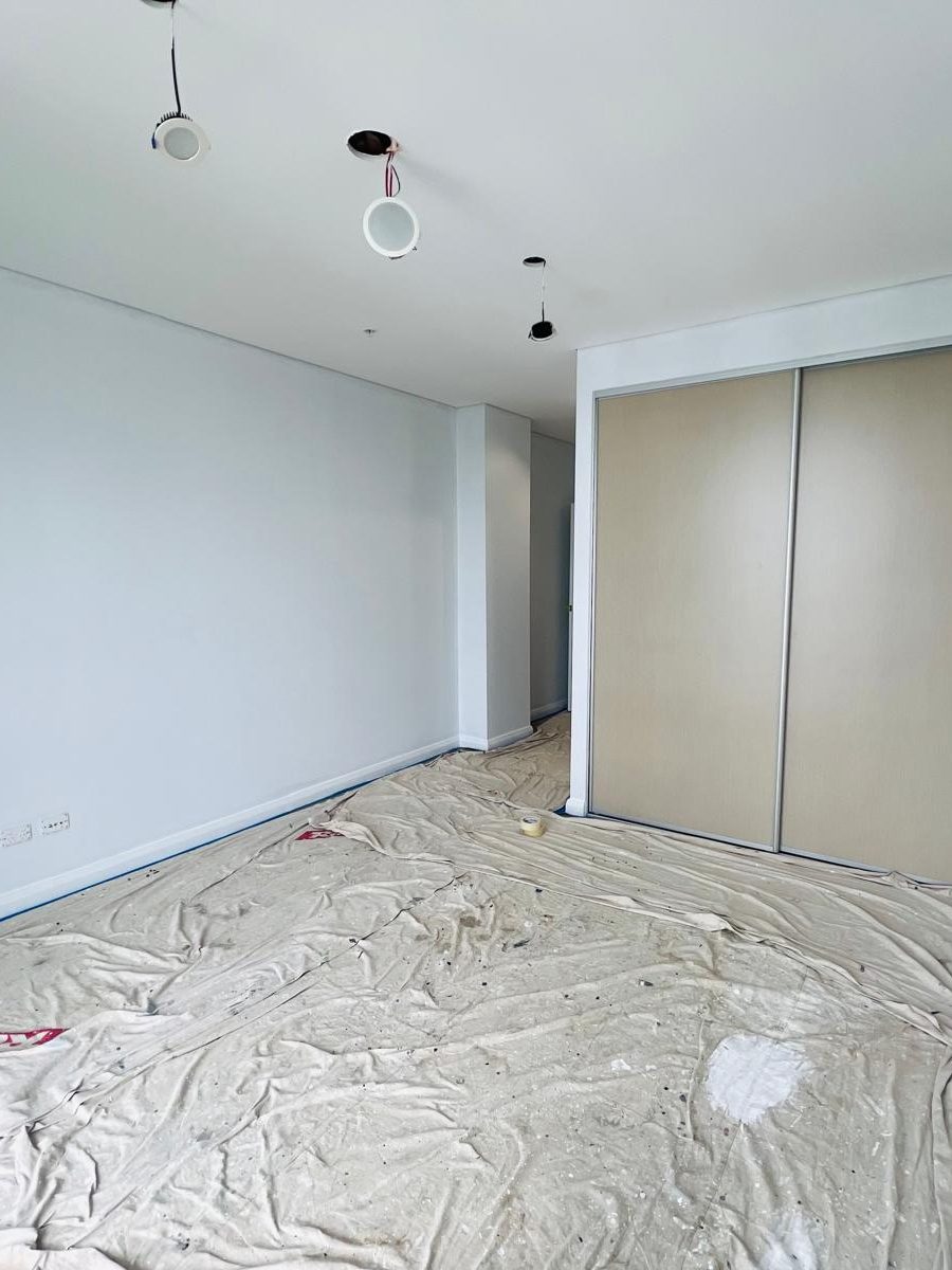 Bedroom with the ceiling set flush, the walls finished and a built in wardrobe in place