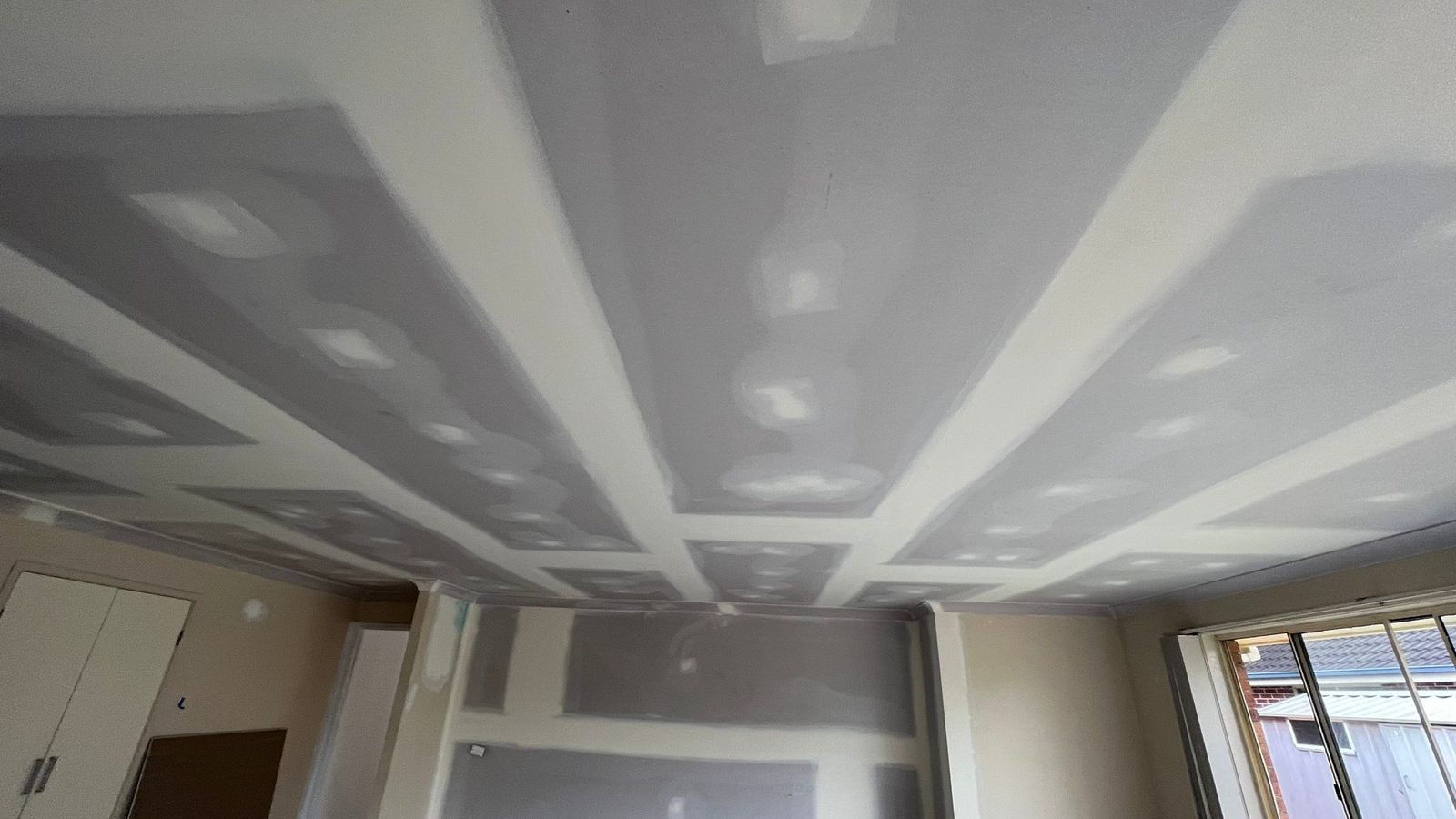 Ceiling with the joints coated wide and the fixings spotted, the surface ready for sanding