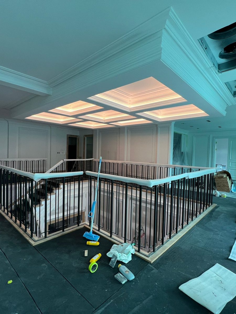 Coffered ceiling with concealed lighting above a landing and balustrade