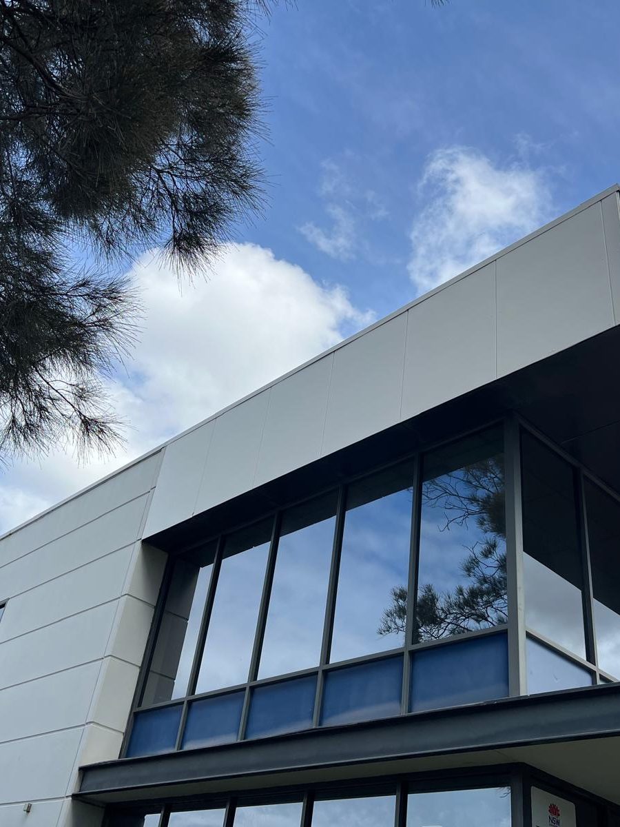 Exterior of a modern two storey commercial building with full height glazing and flat white cladding