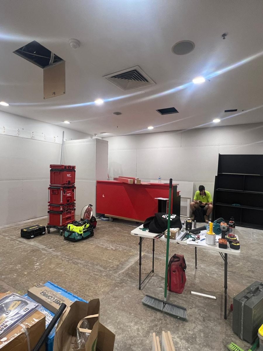 Commercial room with the ceiling set and downlights fitted while the fixtures are installed