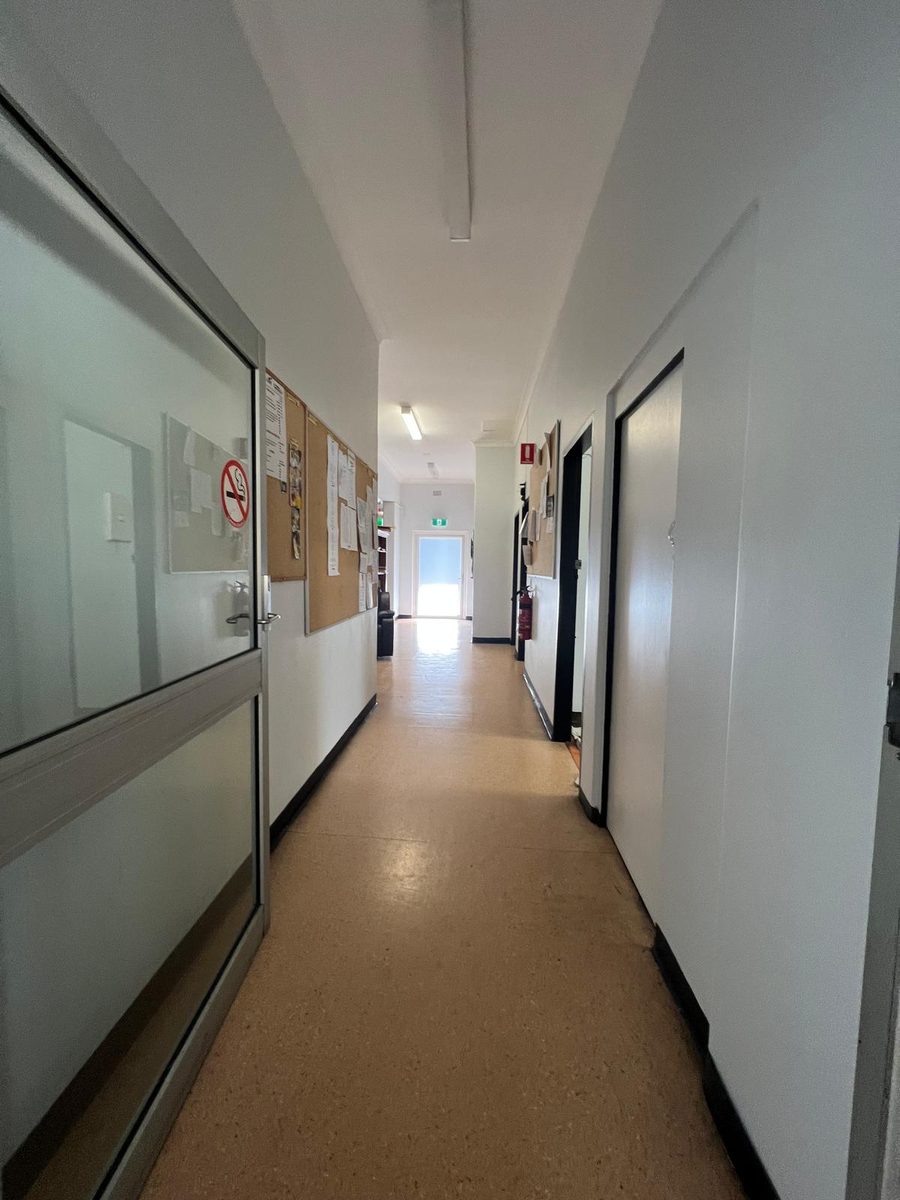 Corridor with the walls and ceiling set and painted past a run of doors