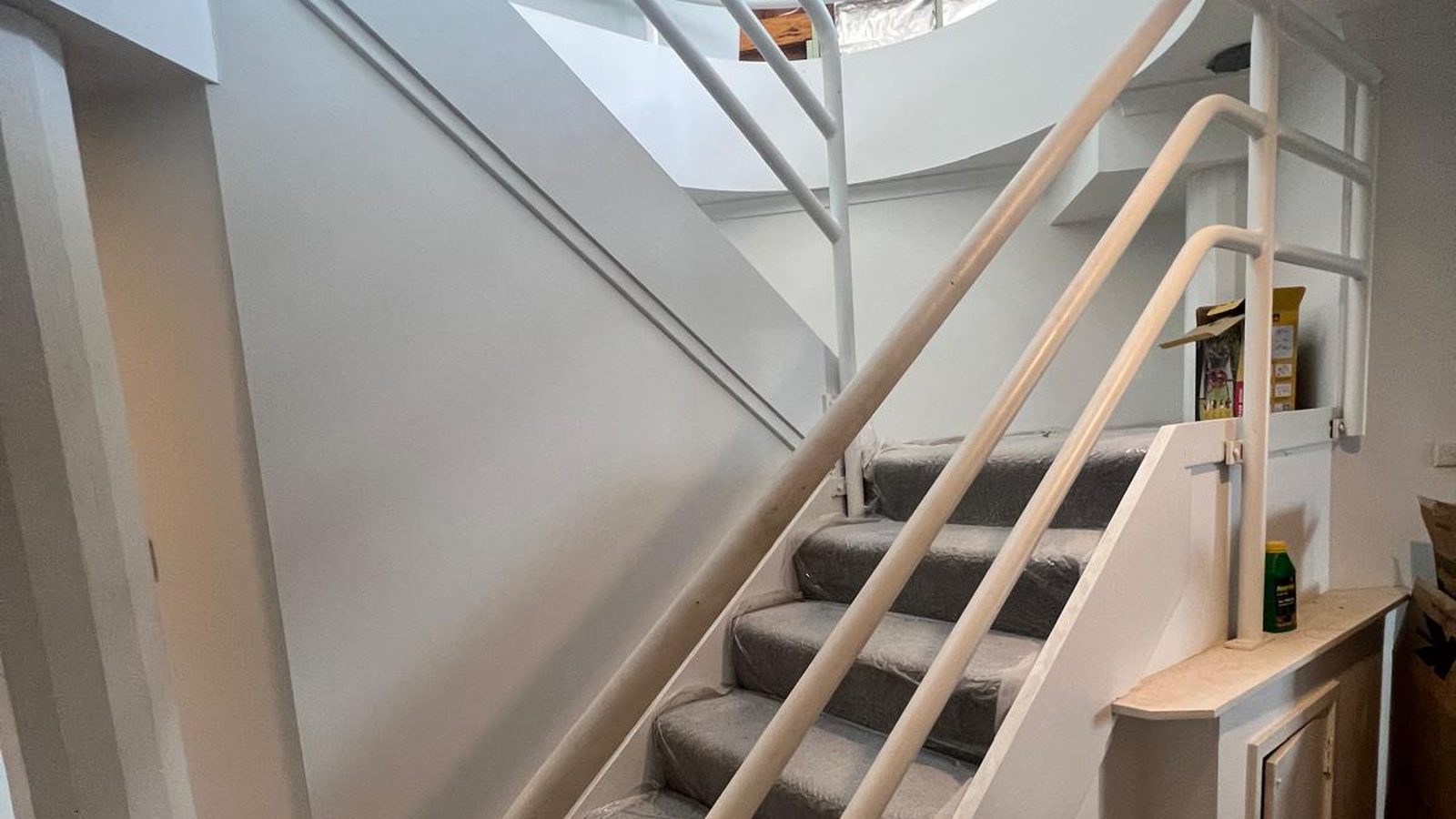 Curved stair wall and built in shelving set in plasterboard and finished white