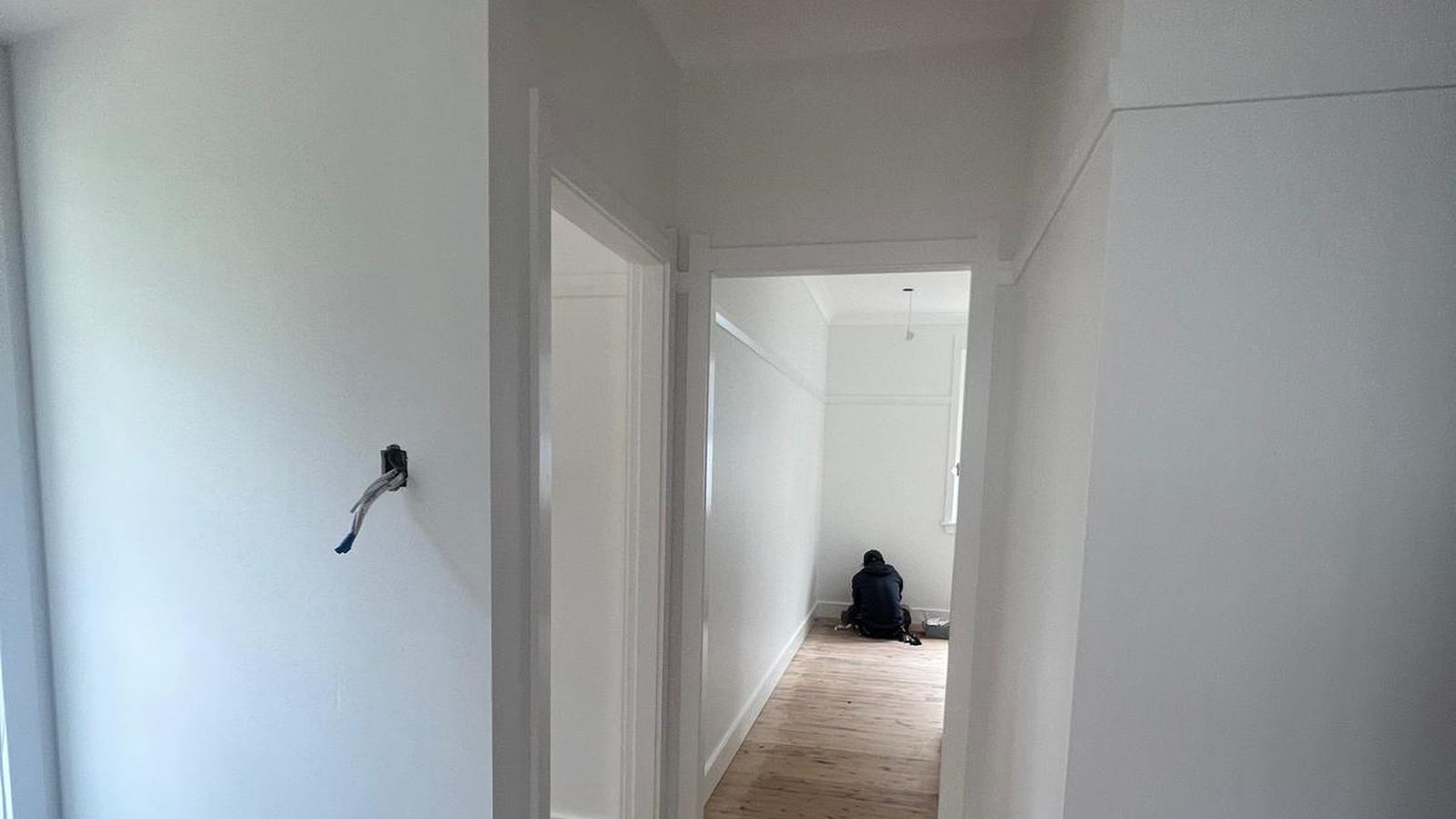 Doorway and the surrounding wall set flush and finished, looking through to the next room