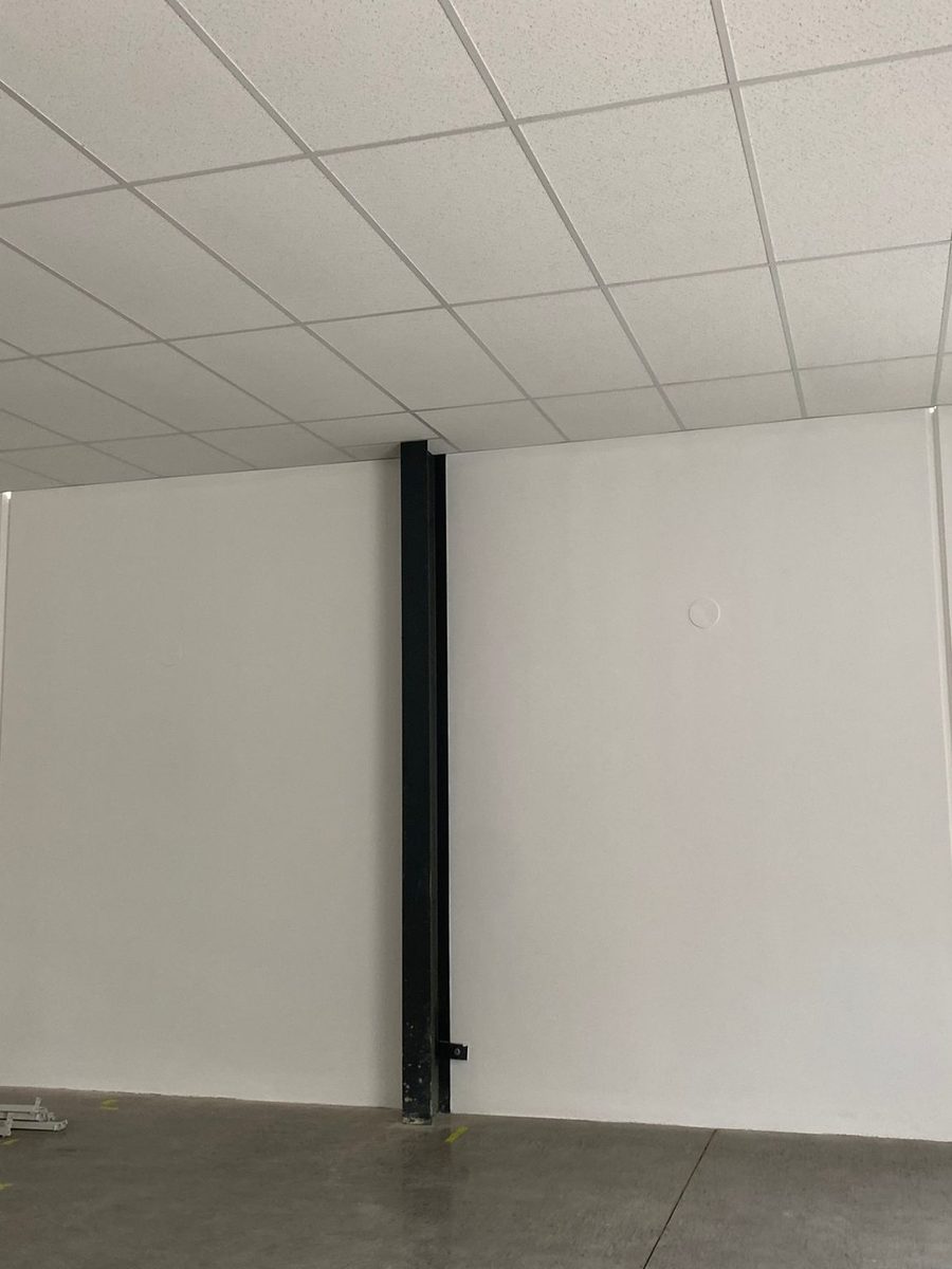 Suspended grid ceiling meeting a set wall in a finished room