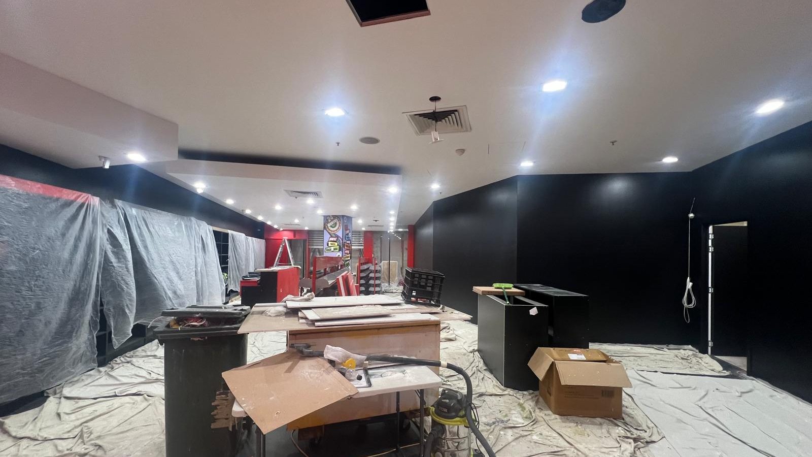 Hospitality interior with the ceiling set and downlights fitted above dark painted walls