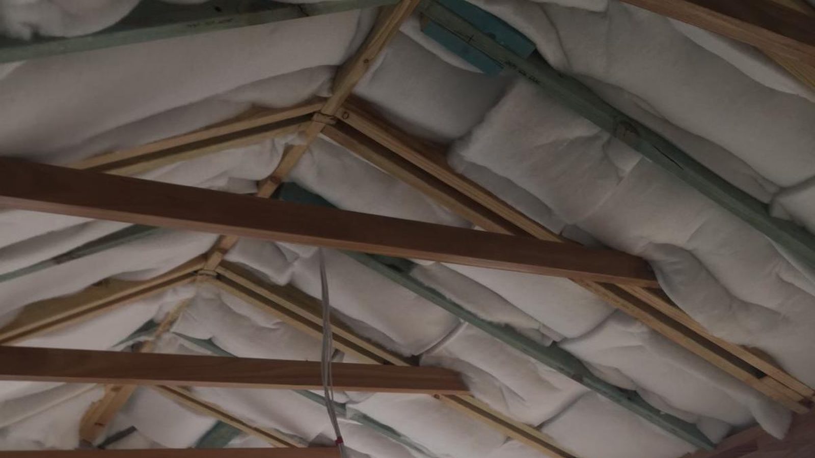 Insulation laid between the rafters above, seen from inside before the ceiling is lined