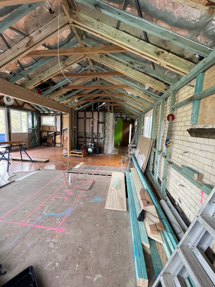 Interior stripped back under an arched timber roof frame, with the walls opened to the brickwork