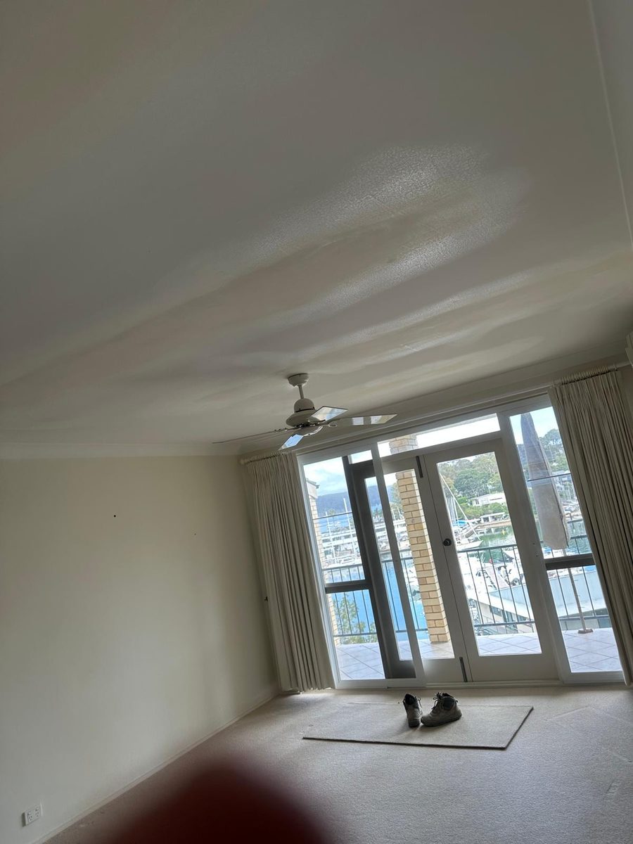 Living room with the ceiling set flush and painted, a ceiling fan fitted and glazed doors to a balcony