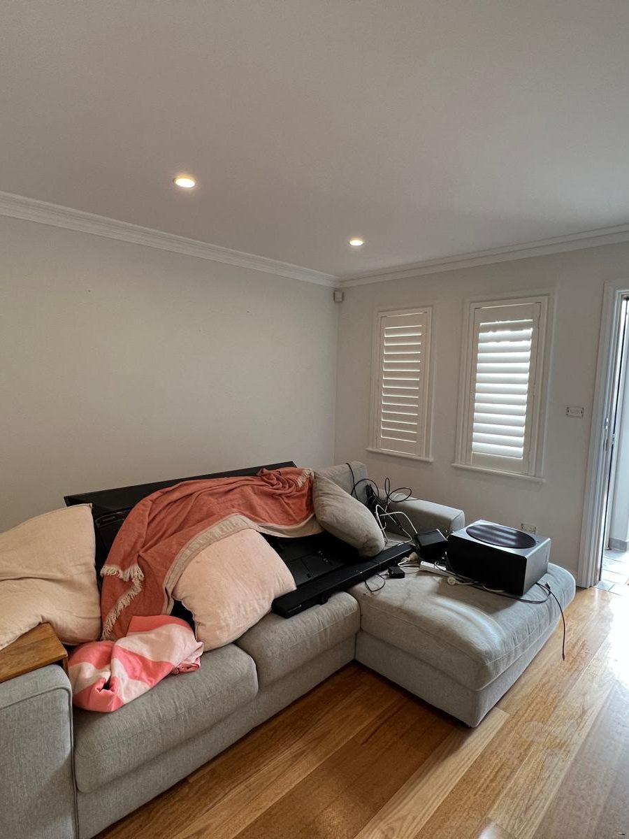 Living room with the ceiling set into a cornice and plantation shutters at the window