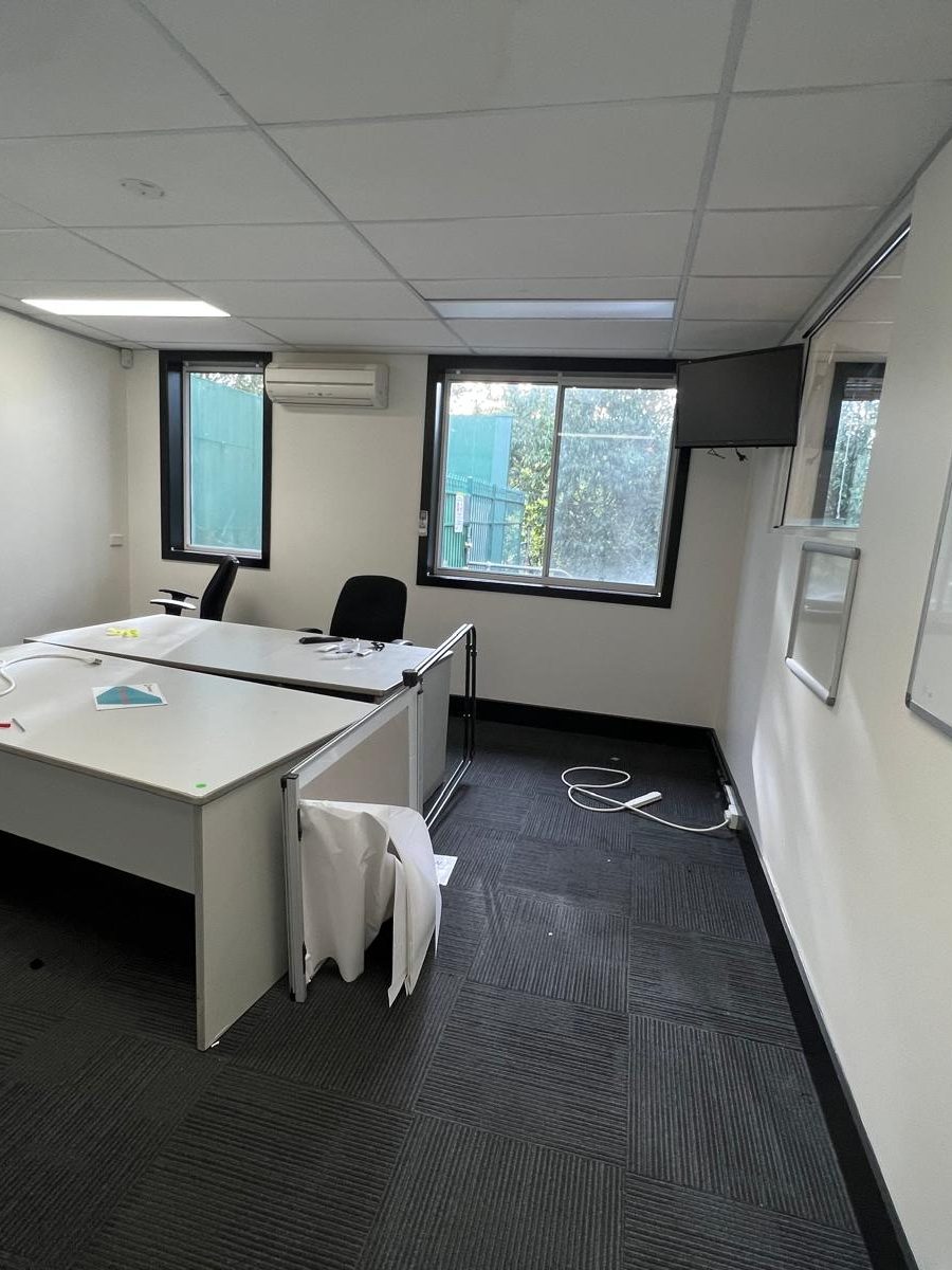 Office room with a suspended grid ceiling, set walls and desks moved in