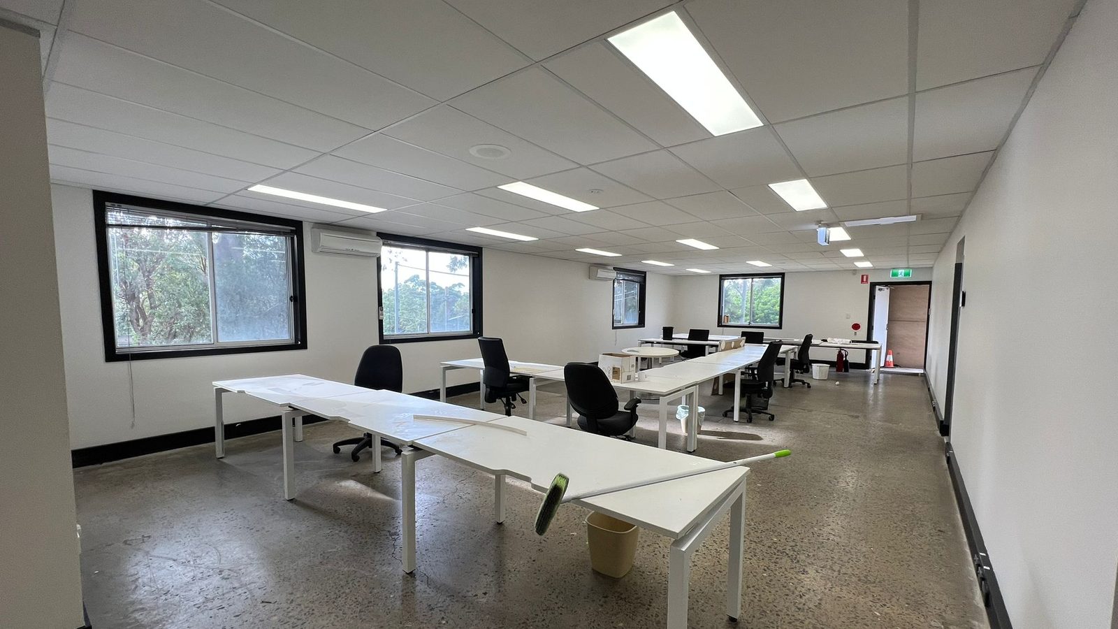 Office floor with a suspended grid ceiling and recessed light panels above set and painted walls