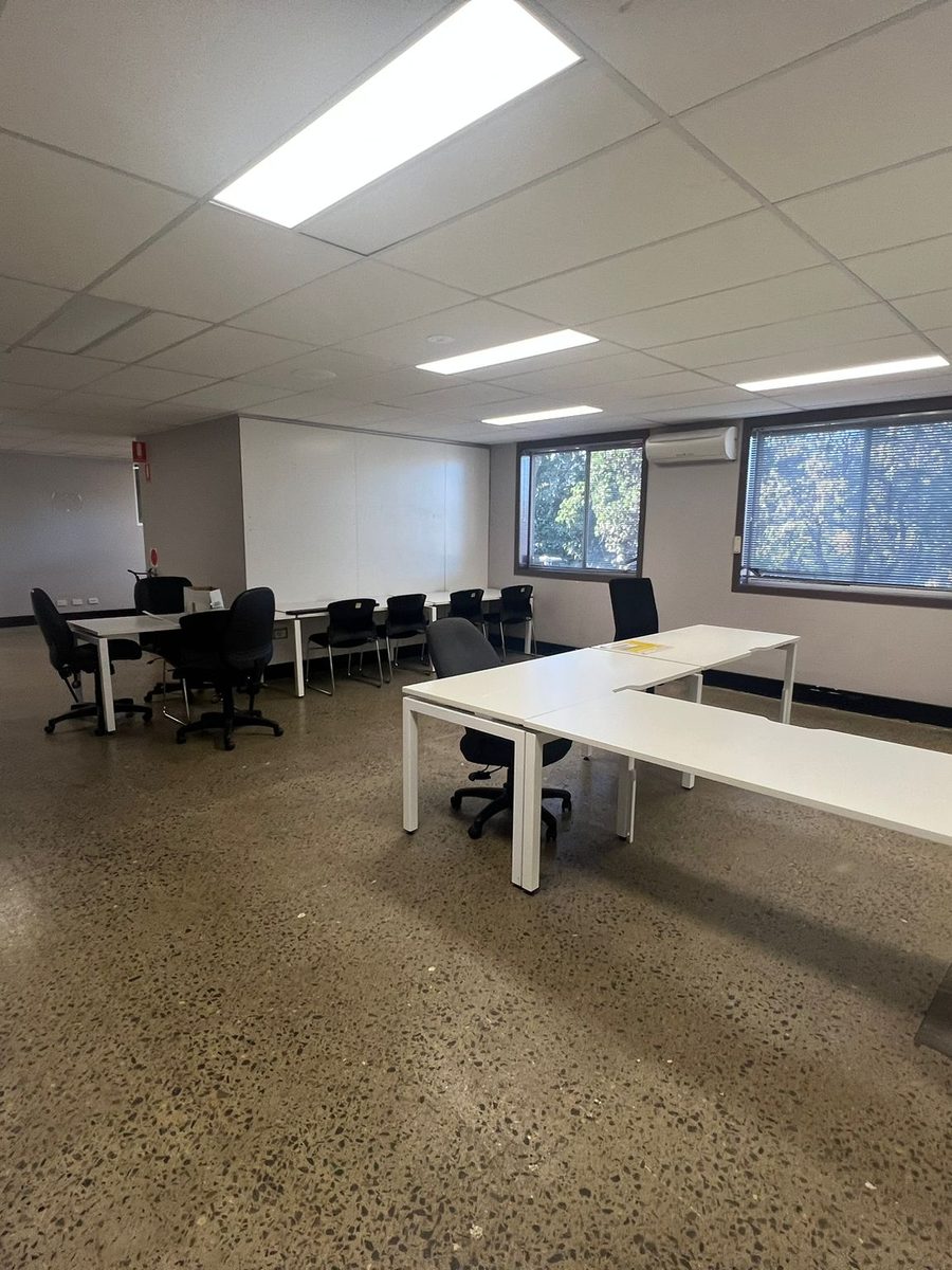 Office room with a suspended grid ceiling, set walls and desks in place