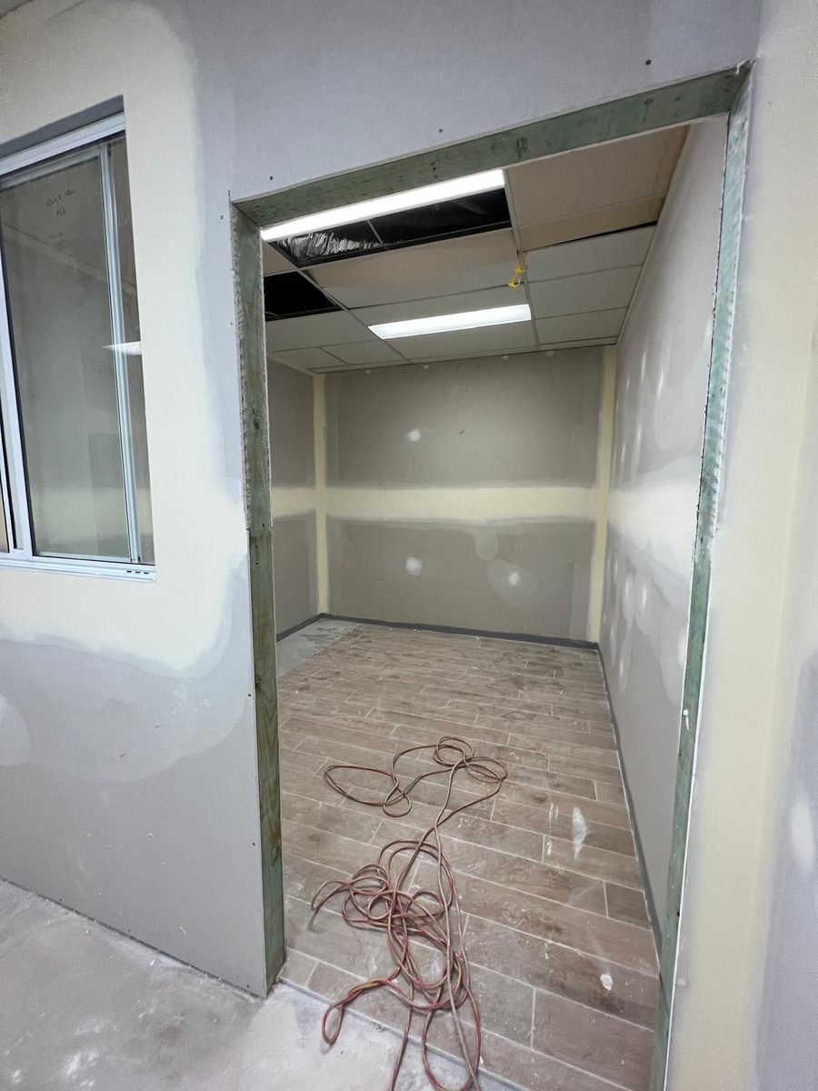 Opening set and lined, looking through into a room with a suspended grid ceiling