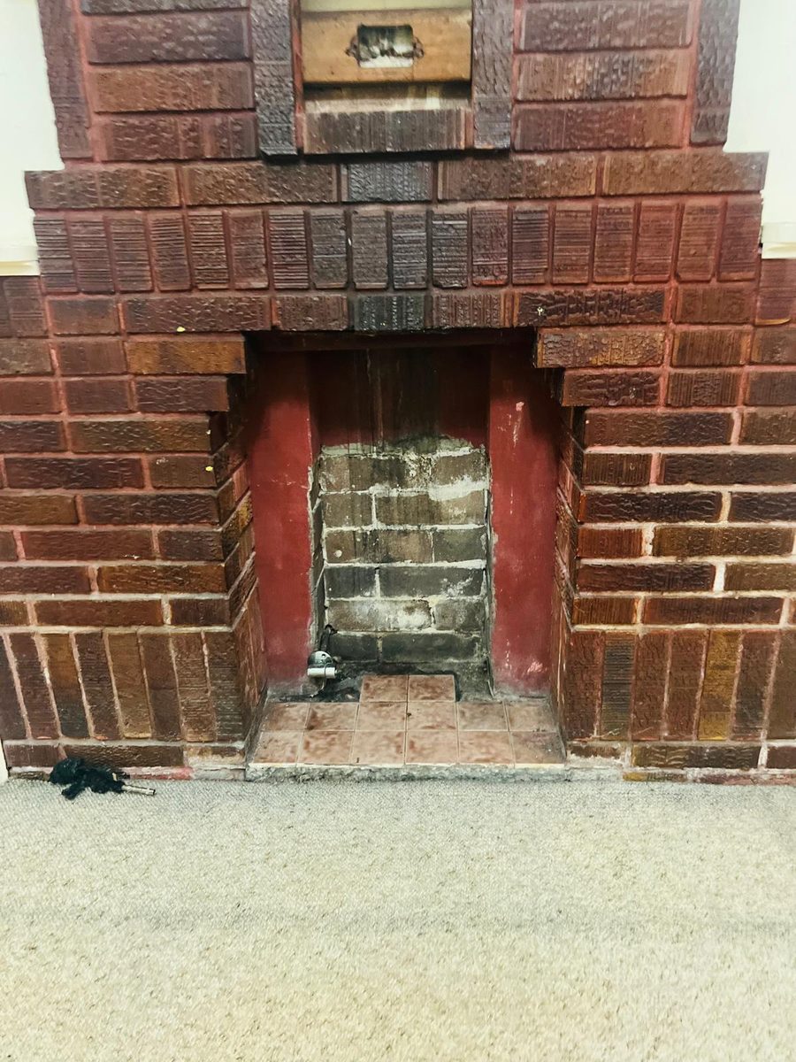 Original brick fireplace and chimney breast left bare, the masonry open before any render or lining