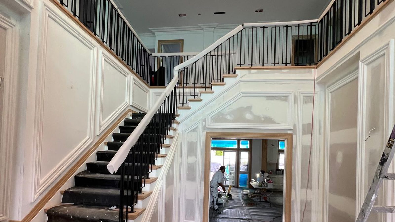 Stair hall with panelled wall linings and a balustrade above, the surfaces being filled and finished