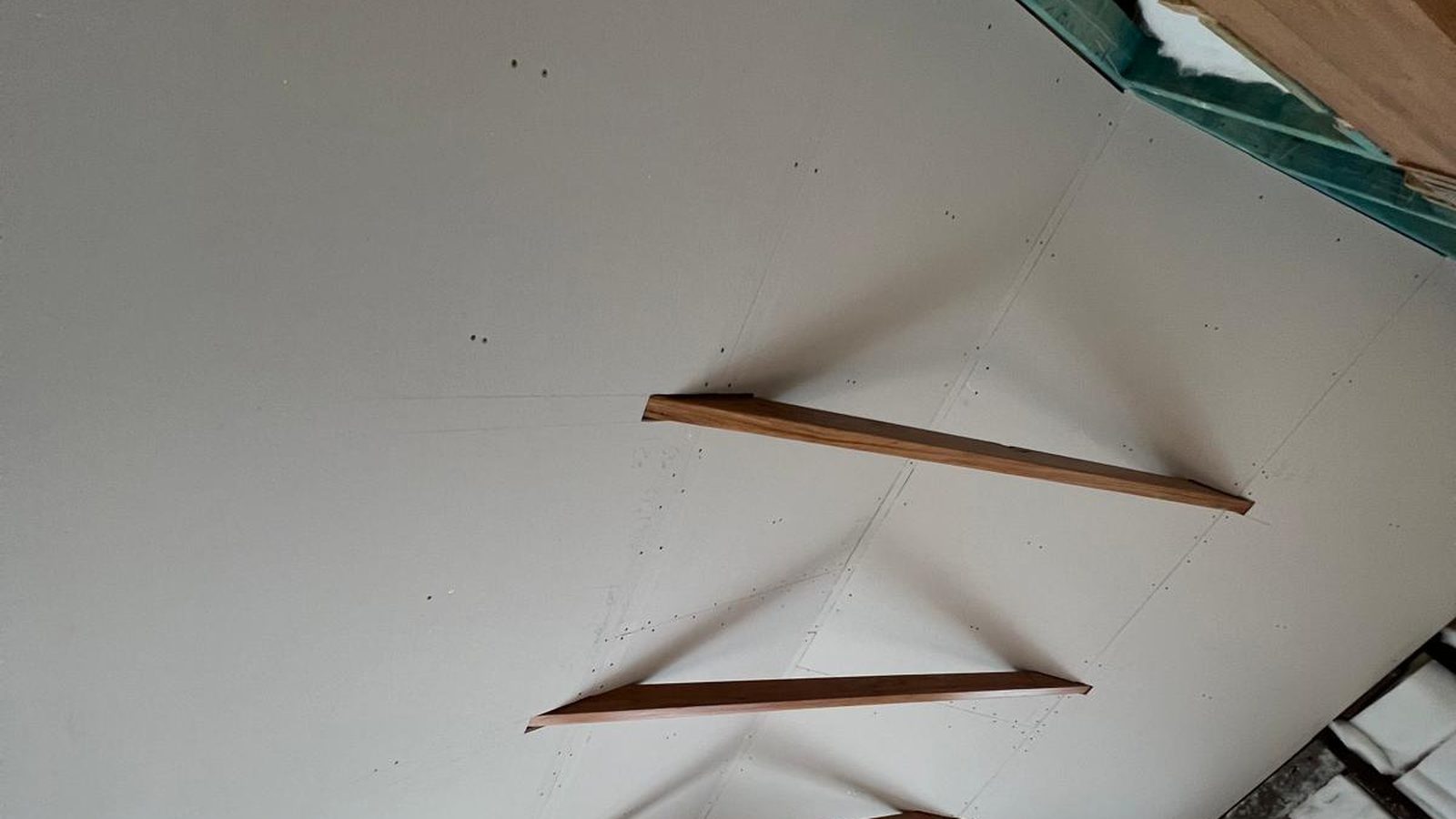 Raked ceiling sheeted around timber struts, the sheets fixed before the joints are set