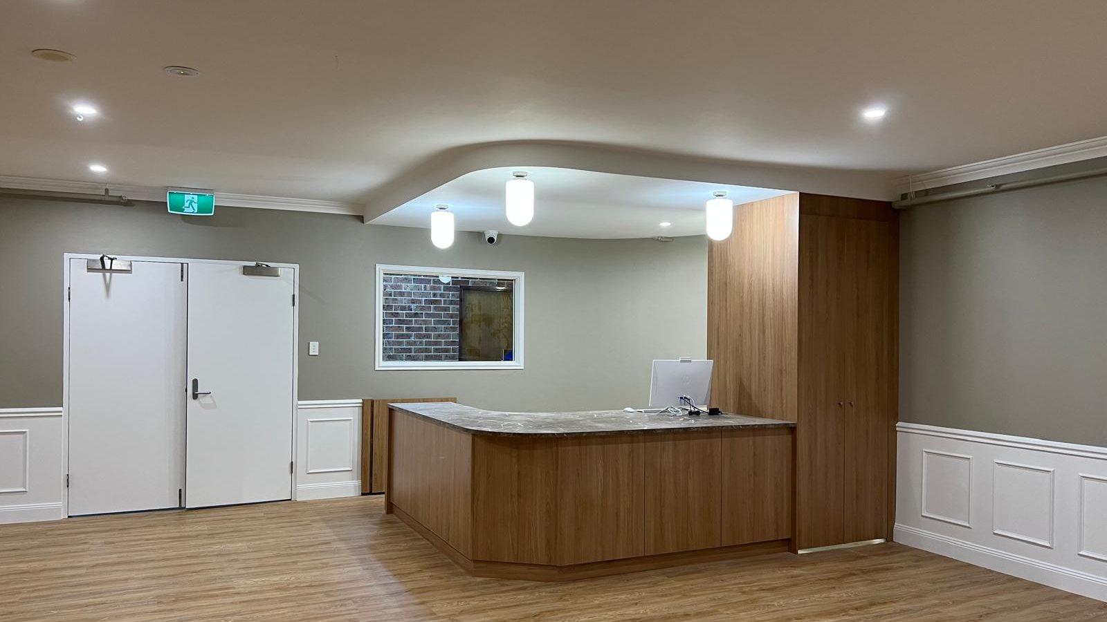 Reception area with a curved bulkhead set into the ceiling above a panelled dado
