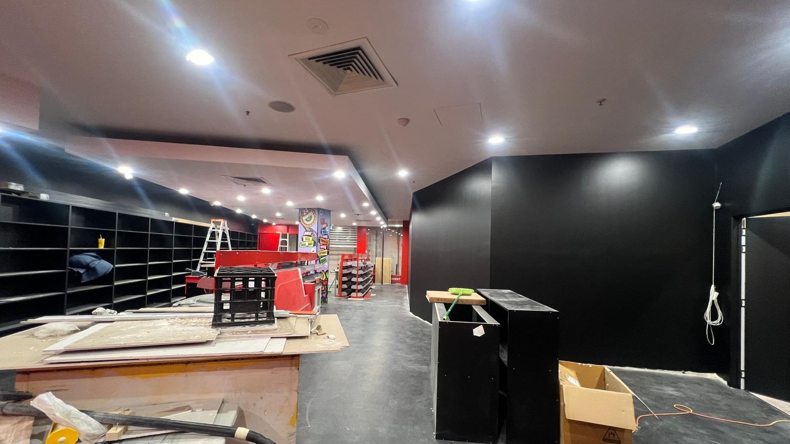 Retail interior with the ceiling set and downlights fitted above new shelving