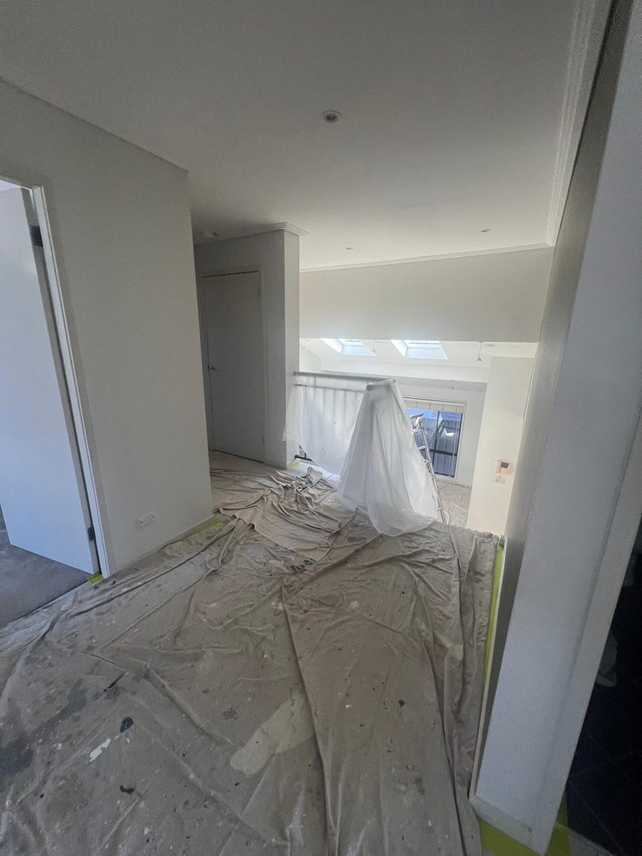 Room with the walls set flush and the floor covered in drop sheets while the work is finished