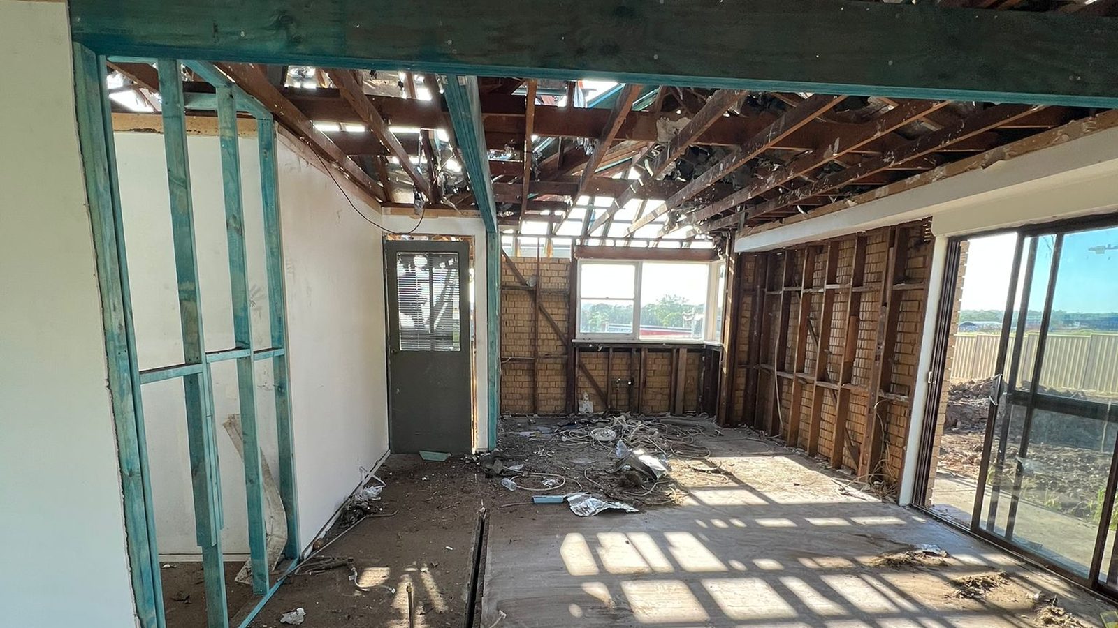 Room stripped back to the frame with the roof structure open above and the old linings removed