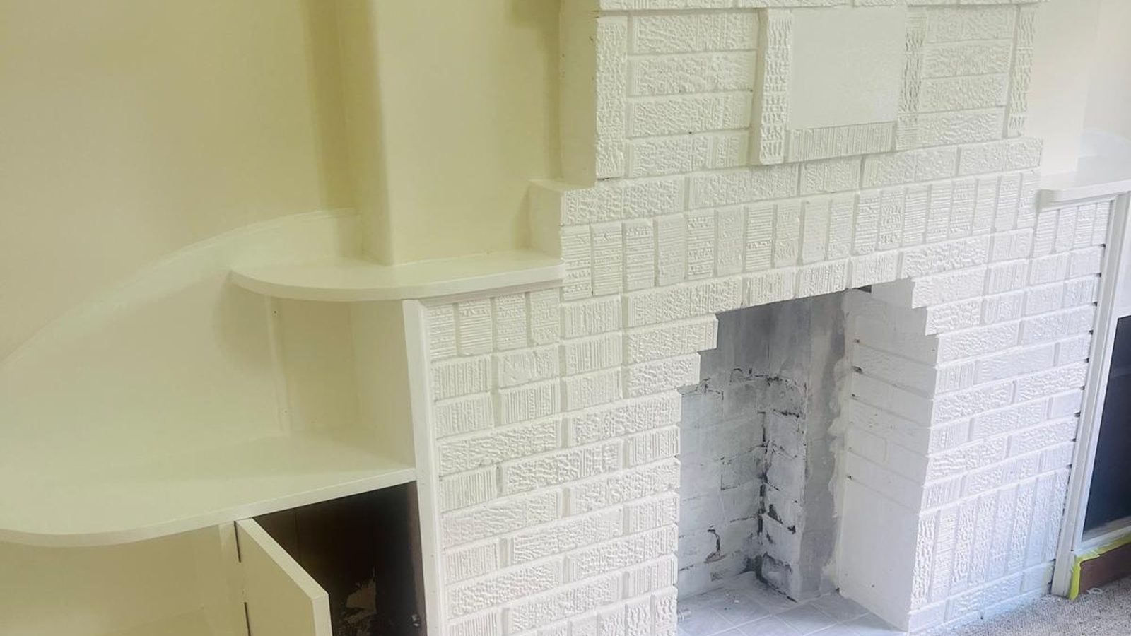 Wall set and finished beside a painted brick chimney breast, with a built in shelf returning into the corner