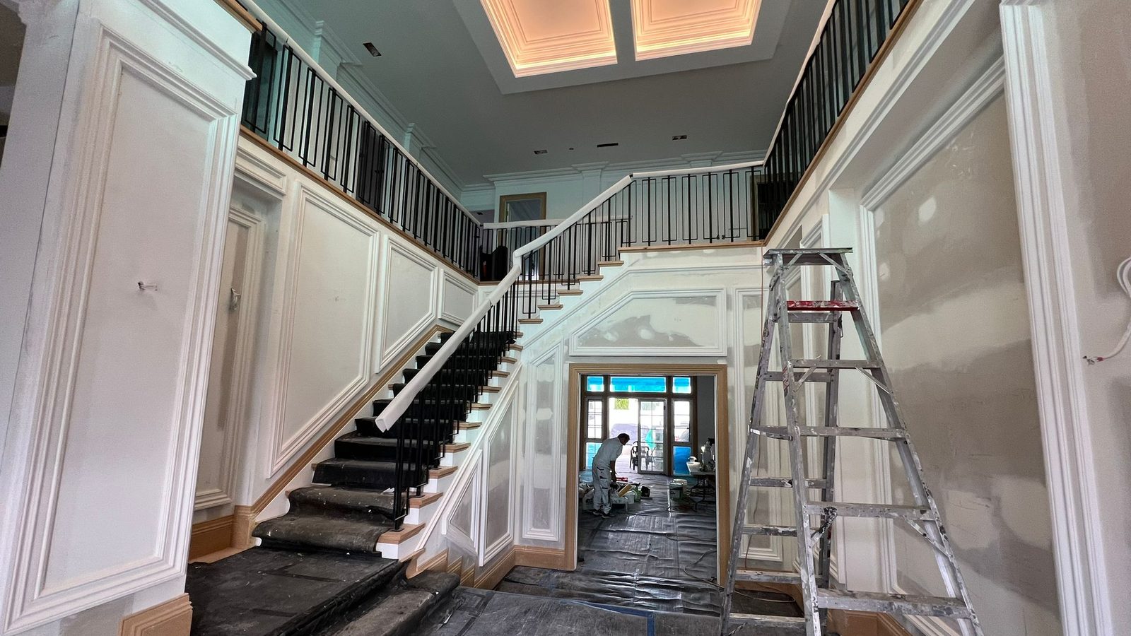 Stair hall with panelled wall linings, a balustrade above and a recessed lit ceiling