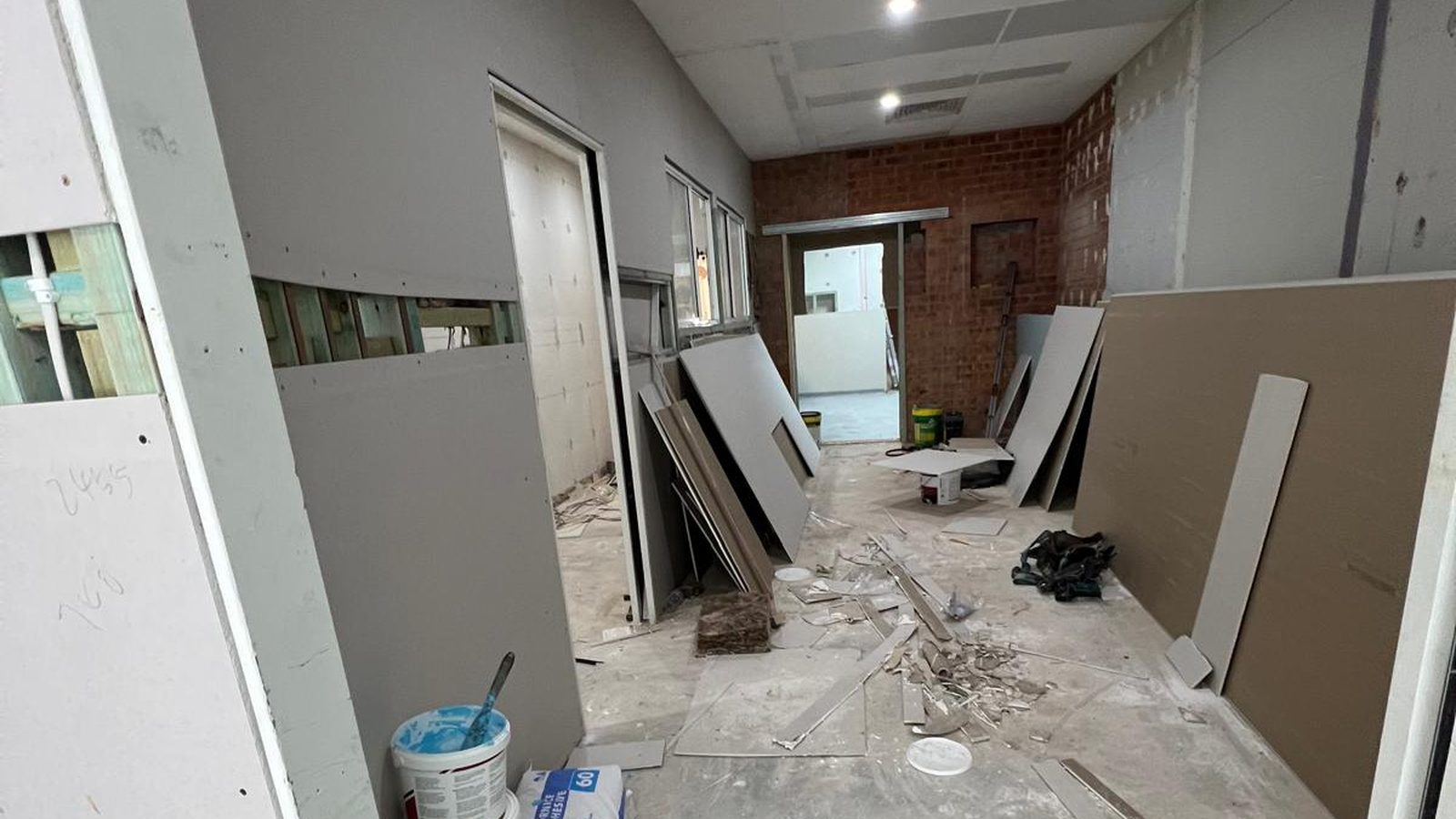 Tenancy being lined, with plasterboard sheets stacked ready and the original brickwork still exposed behind