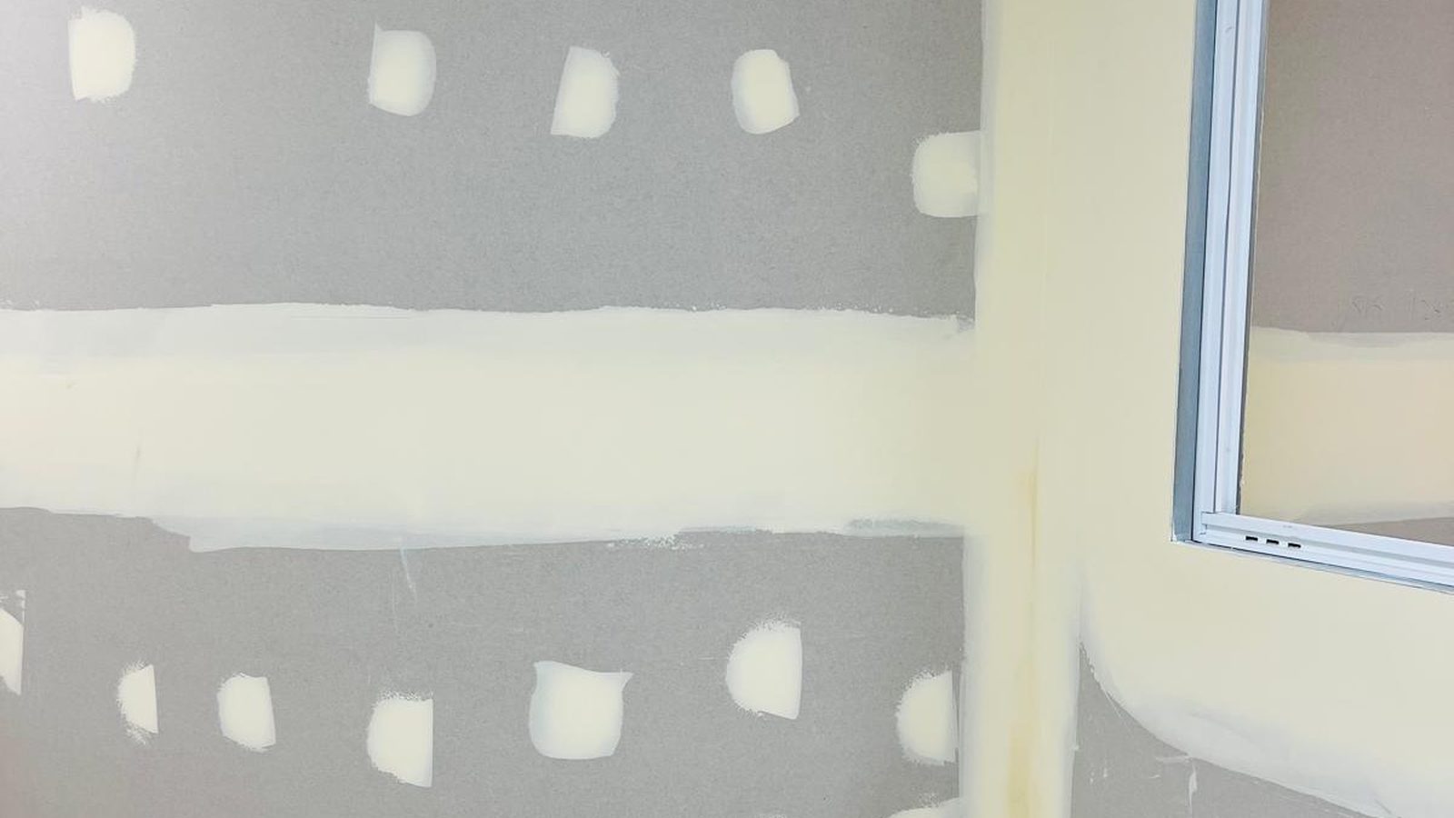 Wall with the joints banded and the fixings spotted, the surface ready to be skimmed