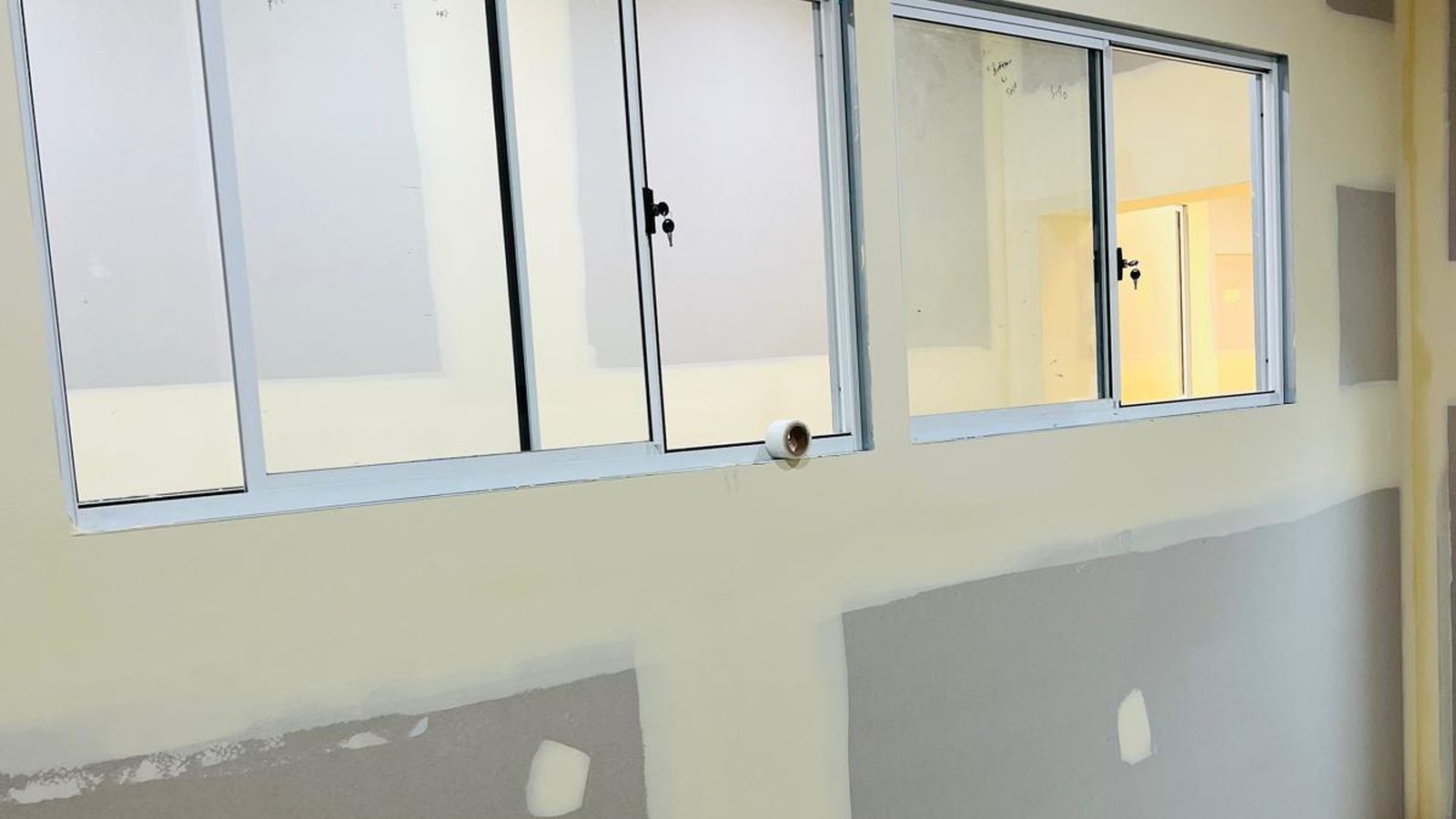 Wall patched and filled around a run of window frames, the repairs sanded back ready for paint