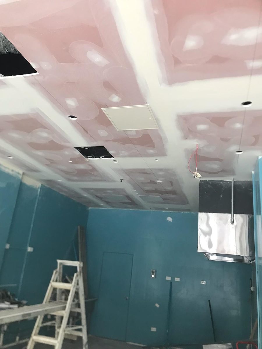Wet area ceiling sheeted and coated around a duct, with the wall lining continuing below